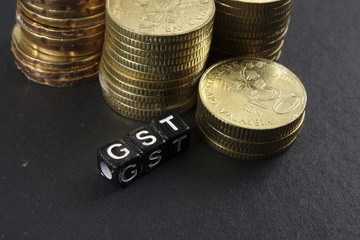 Stack of coins and GST word. Business and taxation concept.