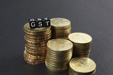 Stack of coins and GST word. Business and taxation concept.