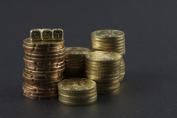 Stack of coins and GST word. Business and taxation concept.