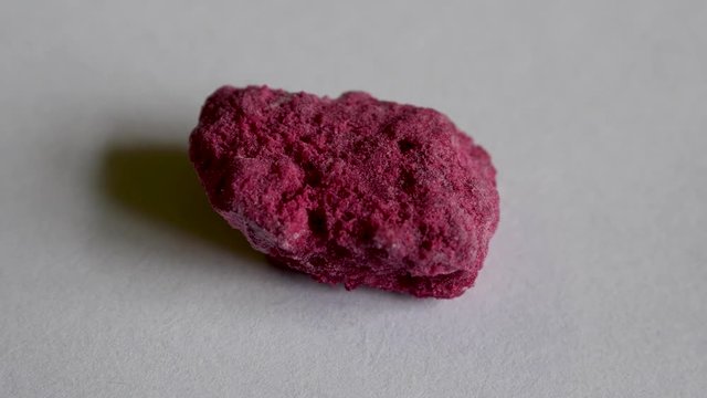 Colored rock with lazurite crystals on white background front view