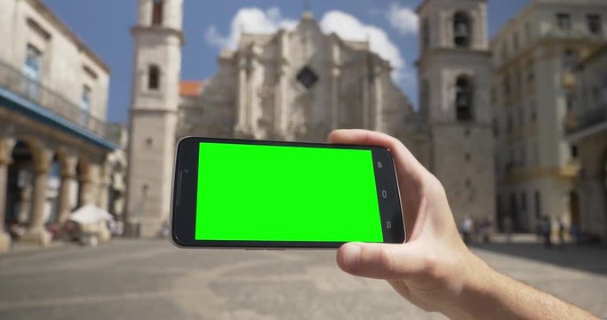 Holding a green screen smartphone in landscape mode outside Havana Cathedral. With optional corner pin markers for advanced tracking.	 	