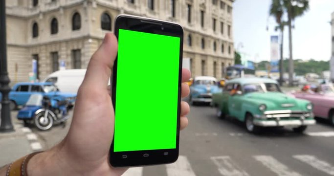 Holding a green screen smartphone near an intersection in downtown Havana, Cuba. With optional corner markers for advanced tracking.  	