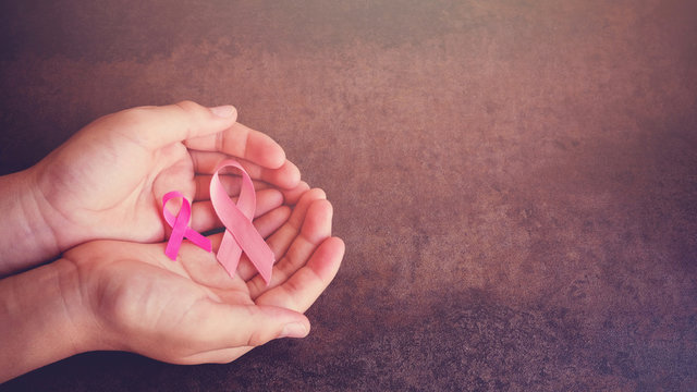 Hands holding Pink Ribbons toning background, Breast cancer awareness and Abdominal cancer awareness