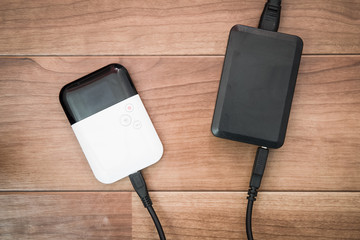 Pocket wifi with battery charger on brown wood table