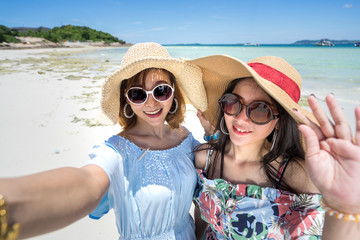Young woman asian buddy in hawaii dress with hat selfie camera view on sea beach summer fun and...
