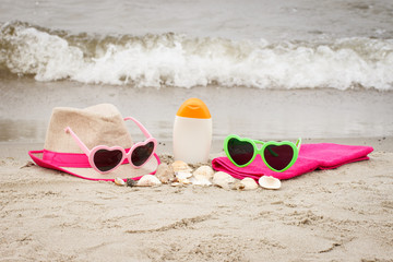 Fototapeta na wymiar Accessories for vacation and seashells on sand at beach, summer time concept