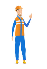 Young caucasian builder waving his hand.