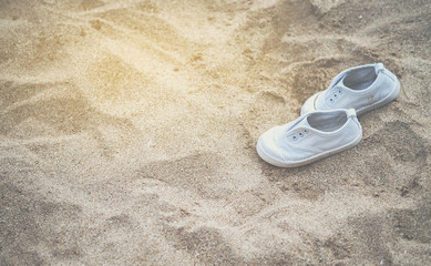 White baby sneakers On the sandy beach