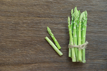 Bunch of fresh asparagus on wood table.