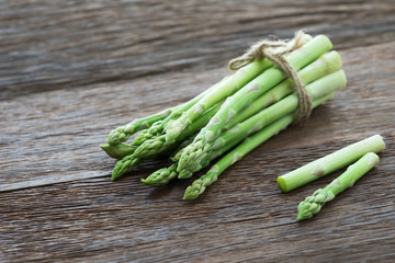 Bunch of fresh asparagus on wood table.