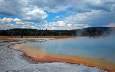 Sunset Lake under cumulus clouds in Black Sand Basin in Yellowstone National Park in Wyoming United...