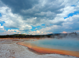 Sunset Lake under cumulus clouds in Black Sand Basin in Yellowstone National Park in Wyoming United States