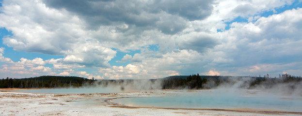 Sunset Lake under cumulus clouds in Black Sand Basin in Yellowstone National Park in Wyoming United States