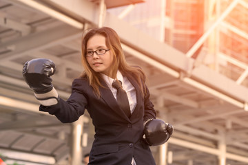 Business woman boxing gloves - business competition concept with businesswoman punching and hitting standing.
