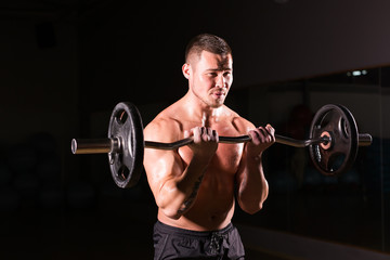 Fototapeta na wymiar young man doing heavy weight exercise for biceps.