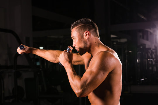 Boxing concept. Boxer man during boxing exercise making direct hit with dumbbells