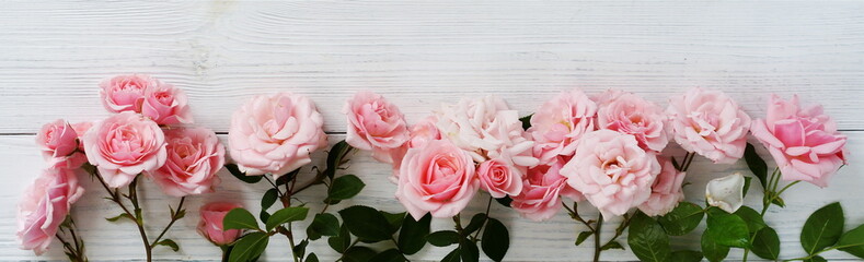 Bouquet of beautiful pink roses on white wooden background.Top view.Copy space.Banner