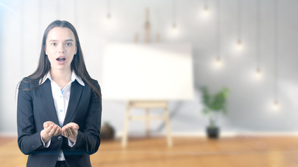 Young beautiful business woman and creative designer standing over blured interior background