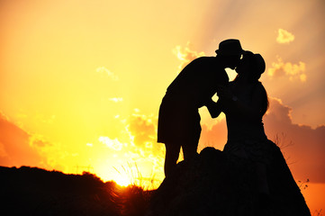 Romantic couple on in love enjoy in sunset. Silhouettes of romantic couple on mountain