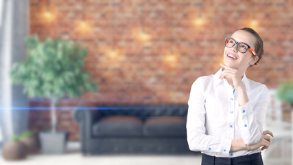 Young beautiful business woman and creative designer standing over blured interior background