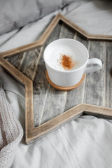 A cup of coffee on a Scandinavian wooden star-shaped tray 