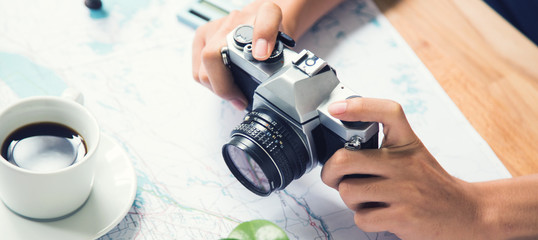 Capture planning map for traveling on wooden table with coffee cup and plant