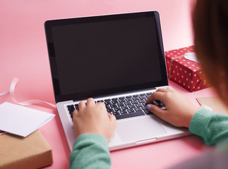 Woman using laptop computer and working on laptop in room