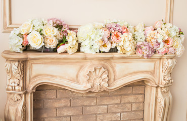 Beautiful beige fireplace with decorative flowers close-up