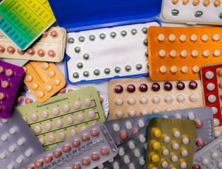 Piles of colorful birth control pills with modern packaging