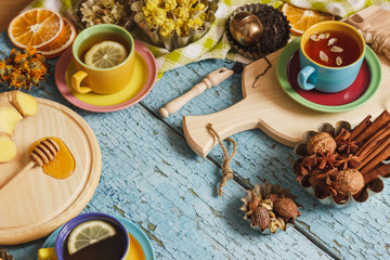 Cups with herbal tea and pieces of lemon, dried herbs and different decorations