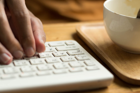 Keyboard typing with cup coffee.