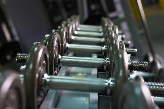Dumbbells in gym. Close up many dumbells in sport fitness centre