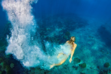 Happy family - girl in snorkeling mask dive underwater with tropical fishes in coral reef sea pool....