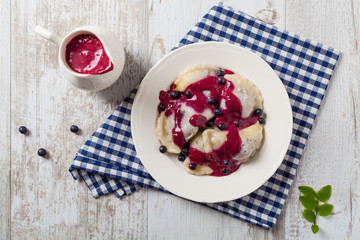Delicious dumplings with fresh blueberries served with whipped cream and sugar or sauce.