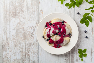 Delicious dumplings with fresh blueberries served with whipped cream and sugar or sauce.