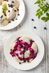 Delicious dumplings with fresh blueberries served with whipped cream and sugar or sauce.