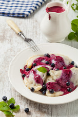 Delicious dumplings with fresh blueberries served with whipped cream and sugar or sauce.
