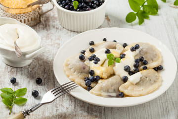 Delicious dumplings with fresh blueberries served with whipped cream and sugar or sauce.