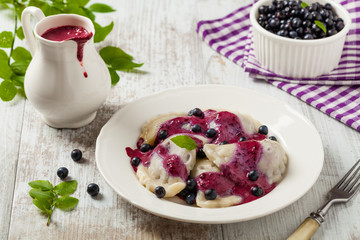 Delicious dumplings with fresh blueberries served with whipped cream and sugar or sauce.