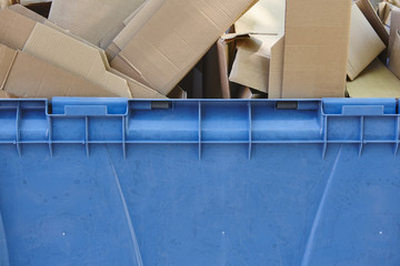 Blue recycling container for paper with cardboard boxes