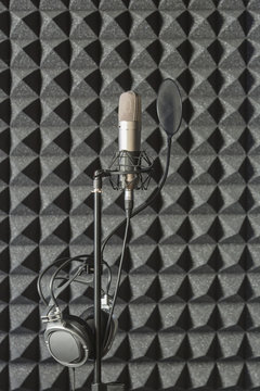 Headphones on microphone stand in soundproof recording studio