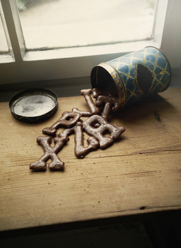 High angle view of alphabet cookies spilling from can on table by window