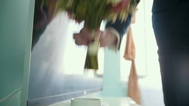 Groom takes wedding bouquet of flowers for the bride