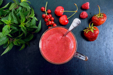 Berry smoothies in a glass mug on a black background. Top view.