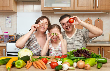 family cooking in kitchen interior at home, fresh fruits and vegetables, healthy food concept, woman, man and children
