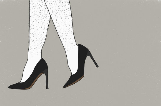 Low section of man wearing stilettos against gray background