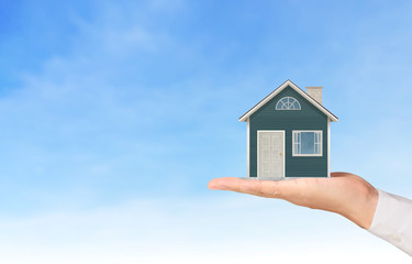 Mortgage concept by house from  hand