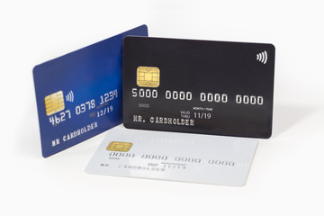 Blue, white and black credit cards on white background