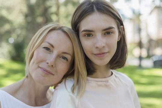 Portrait of smiling mother and daughter at park
