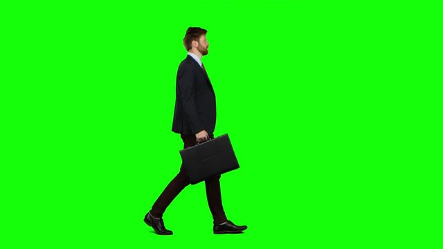 Man holds a briefcase in his hand, he rushes over it. Green screen